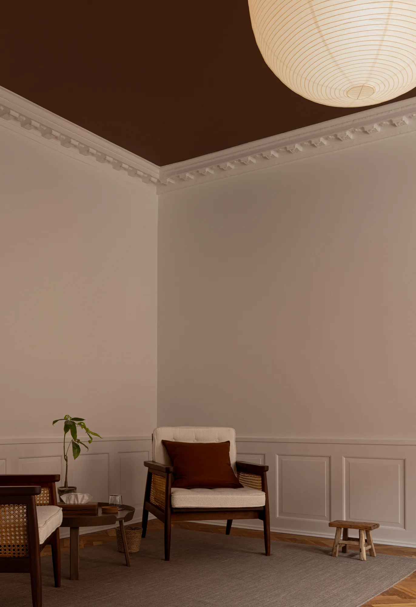 Seating nook in the therapy room at Alethia, Fiolstræde 14, Copenhagen: armchair with rust cushion, small wooden side table and paper lantern in soft lighting