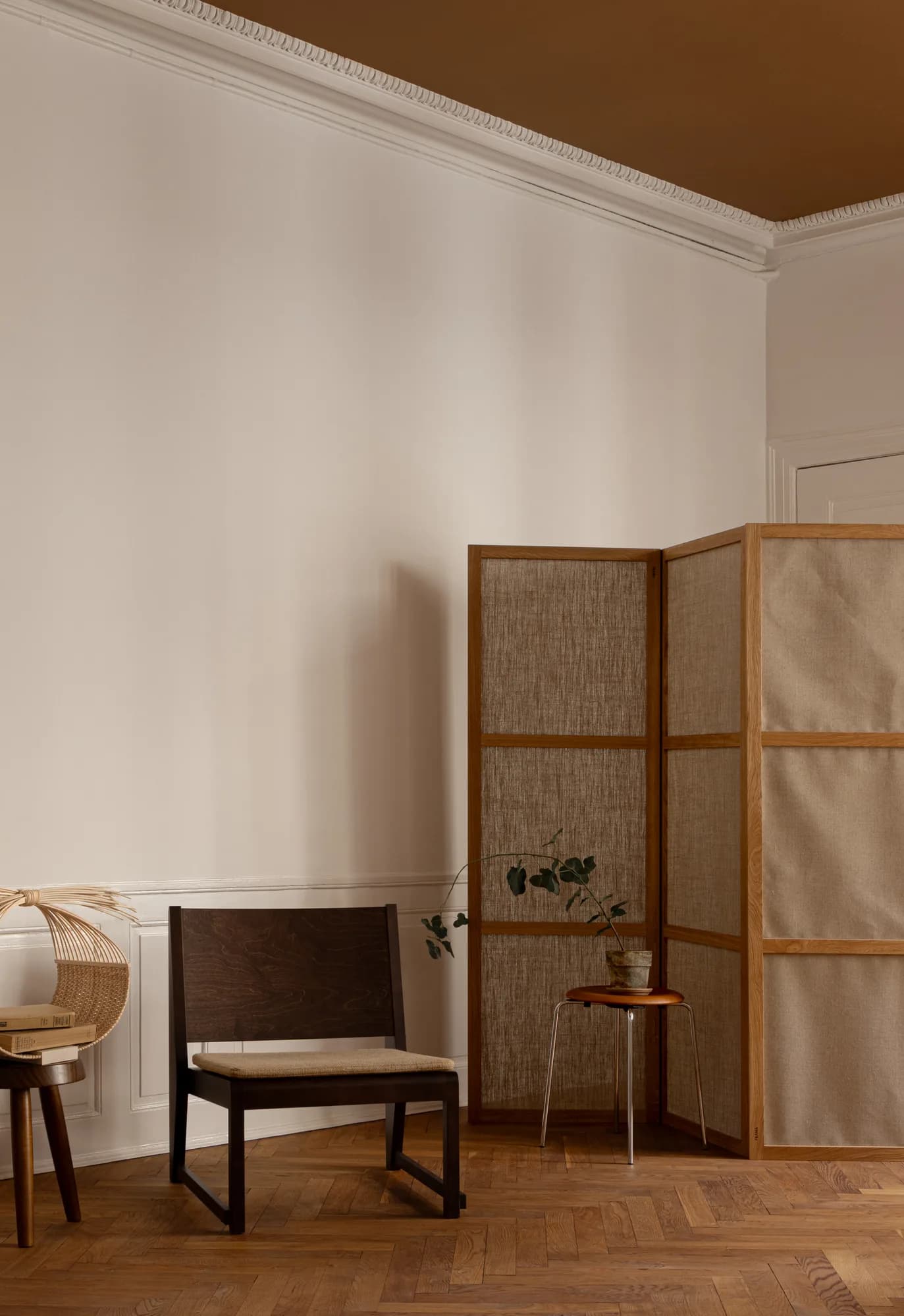 Quiet corner in Alethia clinic, Fiolstræde 14, Copenhagen: dark wooden chair with cane back, folding screen and potted plant