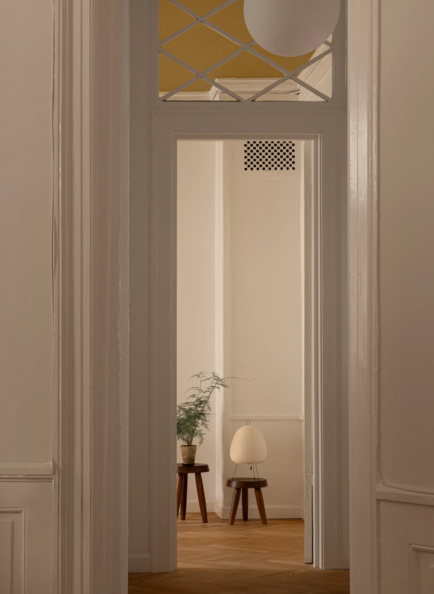 Doorway to a consultation room at Alethia, Fiolstræde 14, Copenhagen: latticed transom, asparagus fern and Akari paper lamp