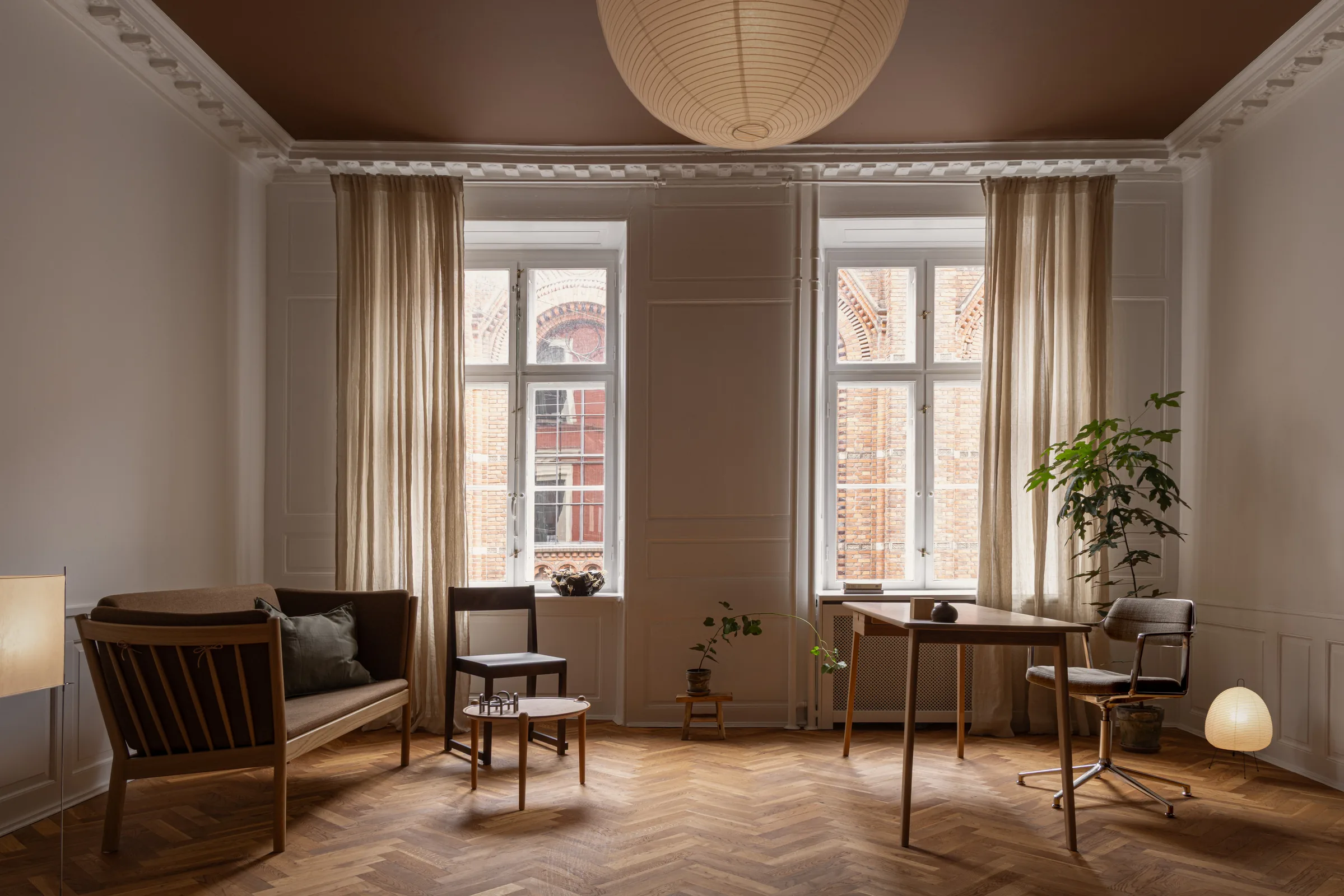 Therapy room at Fiolstræde 14, Copenhagen: panelled walls, Nanna Ditzel chairs, and a view over the Latin Quarter